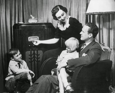 FAMILY GATHERS AROUND A RADIO